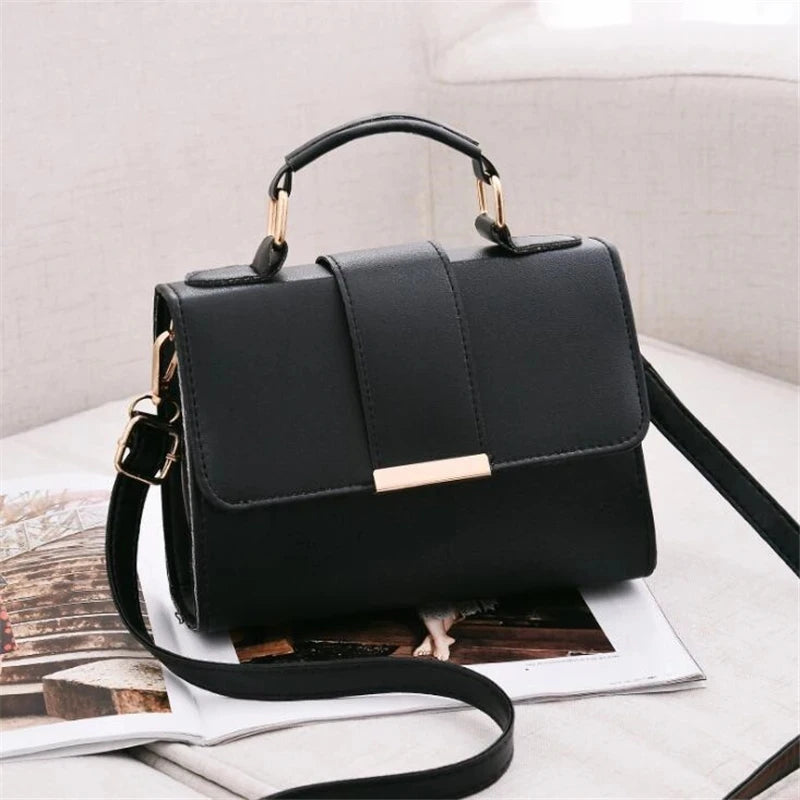Elegant black structured satchel handbag with top handle and gold hardware detail