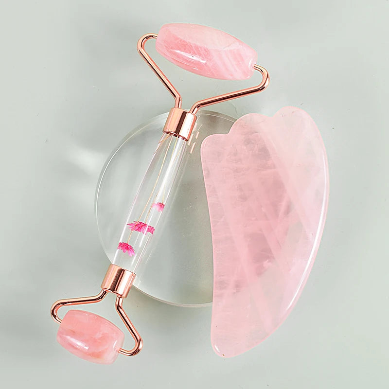 Close-up of a hand holding a rose quartz facial roller with gold details - Aurora Nova 4