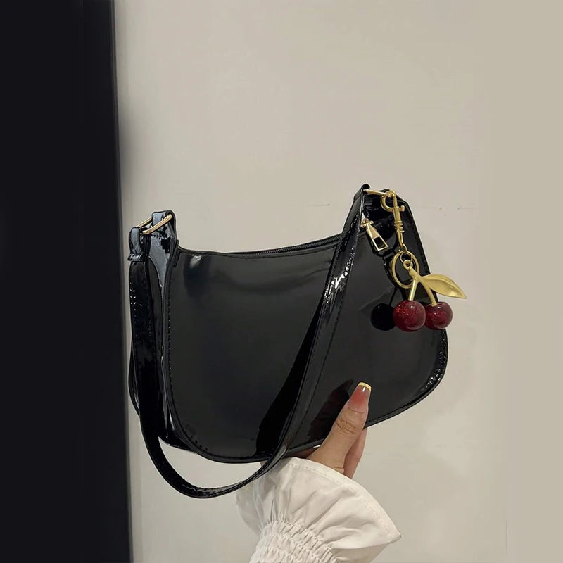 Elegant black leather handbag with premium gold hardware and structured design.
​