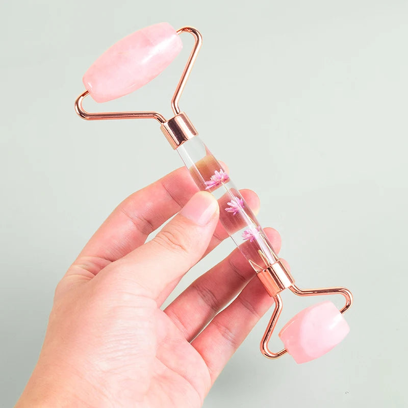 Close-up of a person holding a pink rose quartz facial roller for skincare routine - Aurora Nova 4